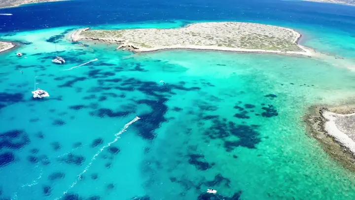 Aerial view of the catamaran anchored at a remote kitesurfing spot.